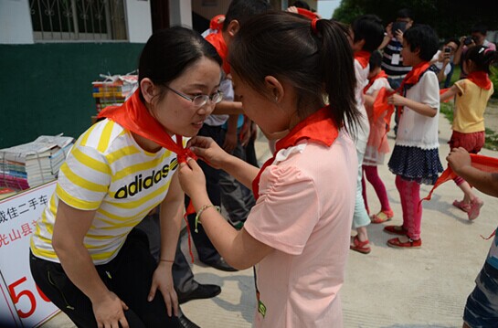 捐贈儀式上，孩子們?yōu)閻坌奶焓瓜瞪霞t領(lǐng)巾