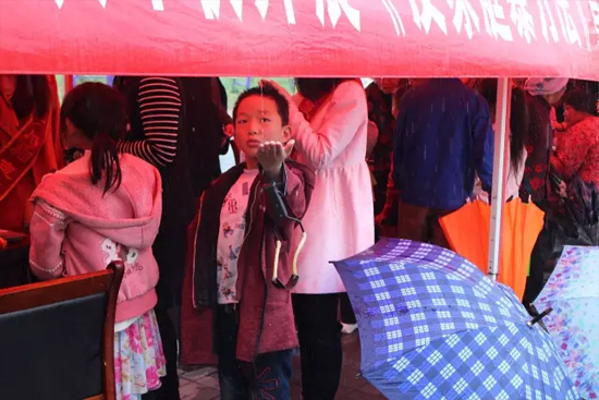 因?yàn)橛晗碌奶?，小男孩玩起了接水游戲? complete=