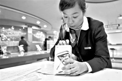 11月6日，北京移動(dòng)西直門營業(yè)廳的工作人員在為顧客購買的4G手機(jī)登記。新華社發(fā)