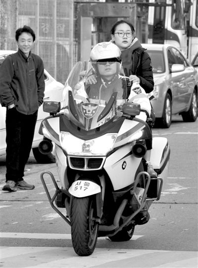 7日，首爾，警察將一名考生送抵考場。新華社發(fā)