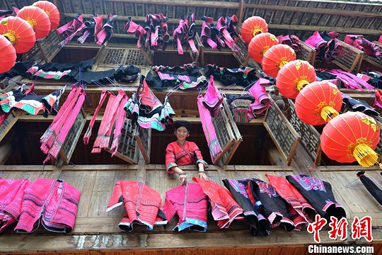 圖為紅瑤姑娘把紅衣晾曬出來。中新社發(fā) 韋吉陽 攝