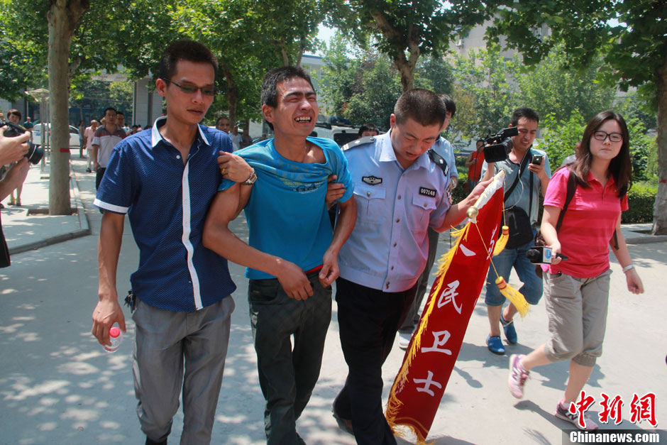 圖為獲救嬰兒父親情緒一度失控，當(dāng)?shù)鼐焦ぷ魅藛T對其進行攙扶。張一辰 攝