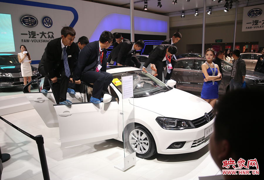 展臺(tái)上幾名工作人員正在演示汽車的性能