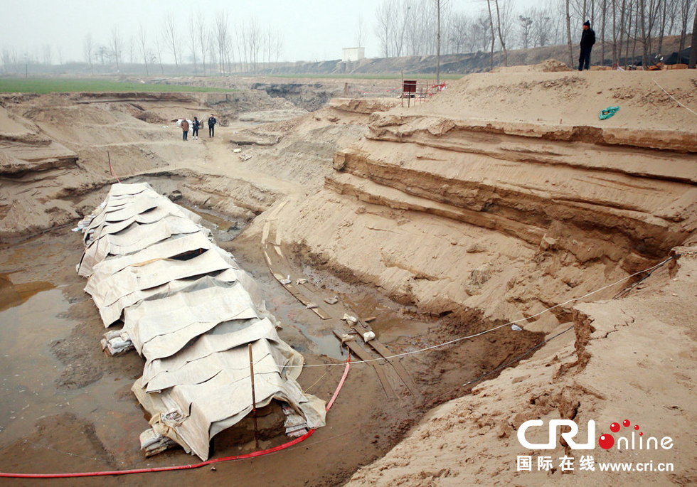 2014年1月6日，河南洛陽古沉船發(fā)掘現(xiàn)場，近日有雨雪天，考古人員給古沉船披上一層“雨衣”。