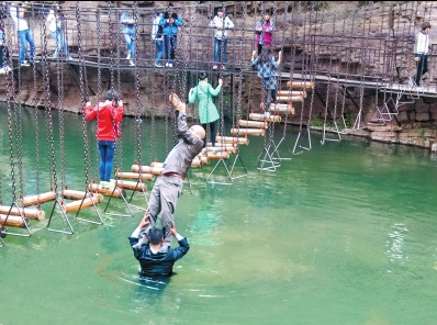 中年男游客正踩著景區(qū)安全員郭小明的肩膀過河。網(wǎng)友“@我的小名叫張孩”供圖