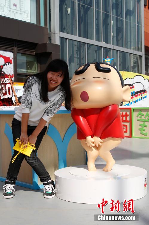 4月22日，游客與蠟筆小新合影。“蠟筆小新25周年紀(jì)念特展”日前在北京開展，吸引了不少市民游客。