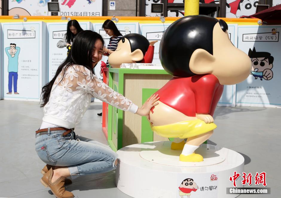 4月22日，游客與蠟筆小新合影?！跋灩P小新25周年紀(jì)念特展”日前在北京開展，吸引了不少市民游客。