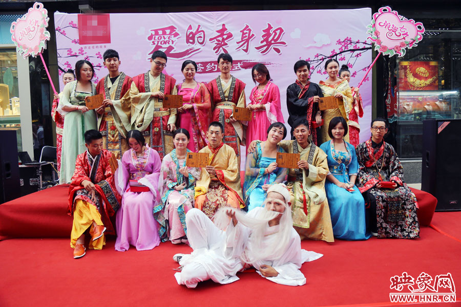 現(xiàn)場8對兒年輕男女舉起“賣身契”集體拍照。