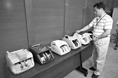 昨日，央行工作人員用各種驗鈔機對C1F9假幣進行測試，機器均能及時作出異常報警反應。新京報記者 浦