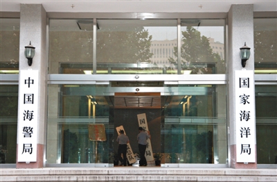 昨日，中國海警局掛牌成立。原國家海洋局和中國海監(jiān)總隊(duì)的牌匾被摘下，國家海洋局和中國海警局的新牌匾換上。黃冉 攝