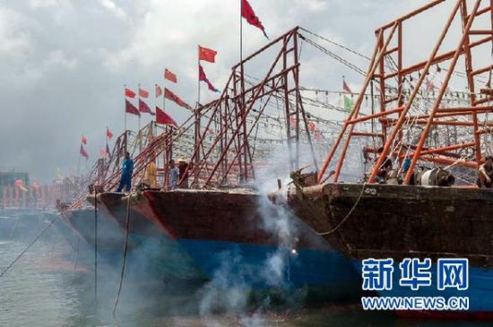 2013年8月1日 南海開漁日 臨高迎新港 8月1日，海南省臨高縣漁民在船上鳴放鞭炮慶祝武蓮港開港。
