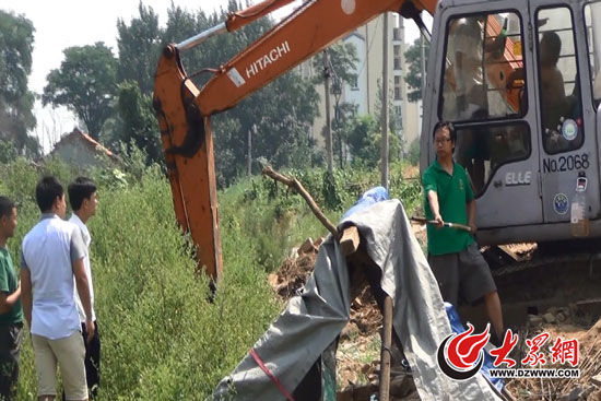 陳寶成手持自制刀斧守在挖掘機(jī)旁阻止便衣民警靠前。駕駛室內(nèi)，張朋珂正向受害人郭曉剛身上澆汽油。（視頻截圖）