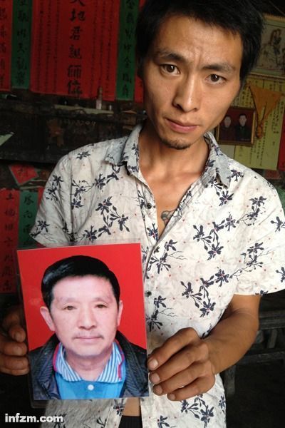 程興貴的兒子程正鵬拿著父親的遺照。程興貴自殺后，政府補償程家6000多塊錢，并終于認定了程興貴的代課教齡。 (南方周末記者雷磊/圖)