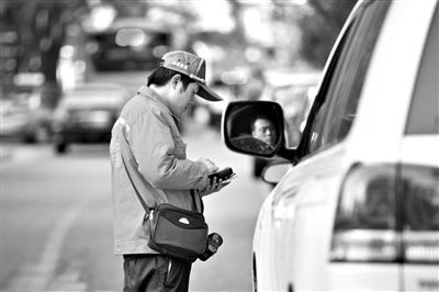 10月15日，朝陽(yáng)區(qū)東大橋路，停車管理員從腰間掏出一個(gè)專用POS機(jī)，正在錄入停車信息。新京報(bào)記者 周崗峰 攝
