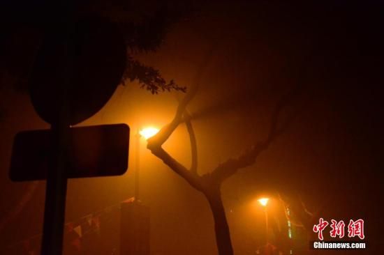 1月31日凌晨，市民行走在煙霧繚繞的南京街頭。當(dāng)天是農(nóng)歷馬年正月初一，南京有限開(kāi)禁燃放煙花爆竹正逢下霧天，空氣的不流通致使煙花爆竹燃燒后產(chǎn)生的顆粒物不能及時(shí)散開(kāi)，造成整座城市煙霧繚繞。據(jù)當(dāng)?shù)丨h(huán)保部門(mén)發(fā)布的信息顯示，空氣質(zhì)量屬重度污染。中新社發(fā) 泱波 攝