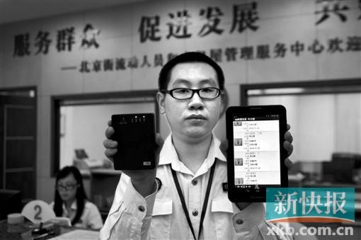 　越秀區(qū)北京街出租屋外來(lái)暫住人員管理服務(wù)中心的工作人員展示到出租屋登記來(lái)穗人員信息的儀器。