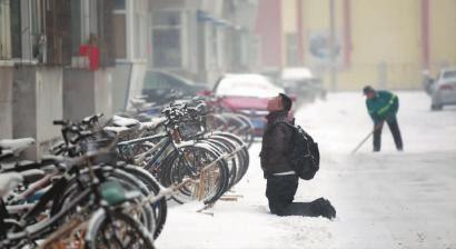 小伙子跪在樓前，一直抬頭看著樓上。 孫立國/攝