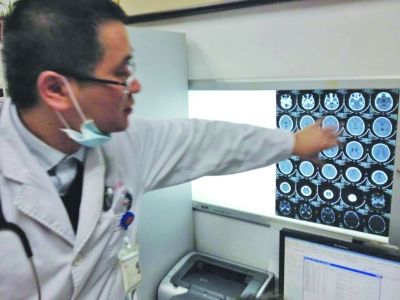 醫(yī)生在查看男孩的腦部CT片。薛馬義 攝