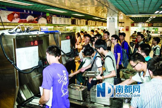 昨日，華南理工大學一食堂內(nèi)，學生們正在使用新安裝的自動打飯機打飯。中新社發(fā)