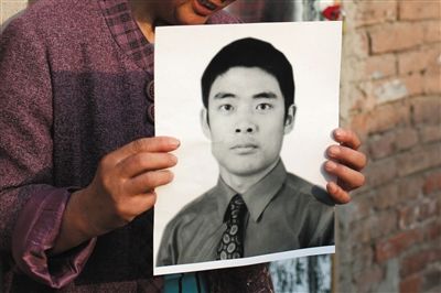 5月19日，朝陽北路，母親捧著張東文的遺像。新京報(bào)記者 侯少卿 攝