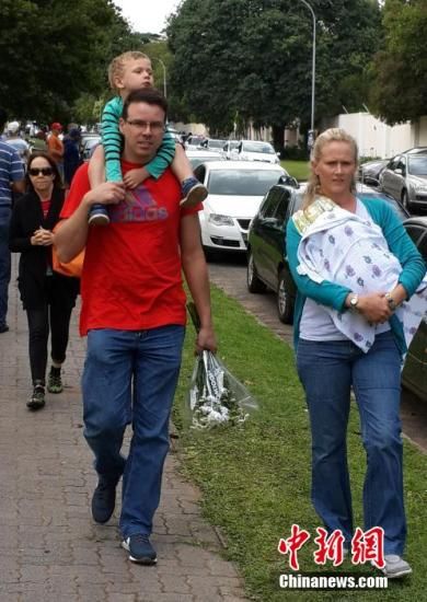 圖為一個白人家庭，由父母帶著孩子到曼德拉家門外悼念。中新社發(fā) 宋方燦 攝