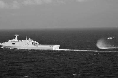 11日，抵達(dá)馬航飛機失聯(lián)海區(qū)的海軍井岡山艦與艦載直升機協(xié)同展開立體搜救行動。新華社發(fā)