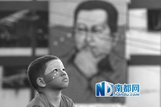3月5日，一名委內(nèi)瑞拉兒童仰望天空，他身后是查韋斯的陵墓。