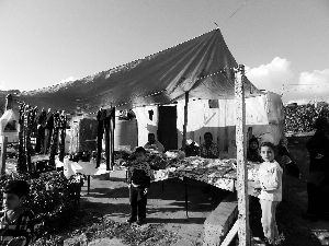 黎巴嫩一敘利亞難民營(yíng)，難民支起攤鋪賣衣服掙錢(qián)。
