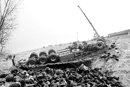 　一輛貨車沖開護(hù)欄翻下高速，輪胎散落一旁