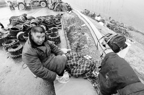 　出事司機(jī)的鞋找不到了，只好用塑料袋套著腳取暖