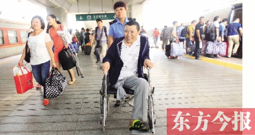李剛手術(shù)后歸來，在車站工作人員幫助下走出鄭州火車站站臺  東方今報首席記者 張曉冬 攝