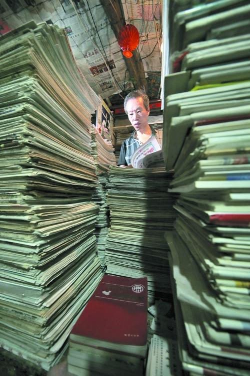 王曉民坐在寫字桌前,被報(bào)紙淹沒。 王曉民坐在寫字桌前,被報(bào)紙淹沒。