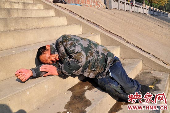 這名男子的衣服以及褲子全濕透了，水從衣褲里流出來，嘴里散發(fā)著濃烈的酒氣。