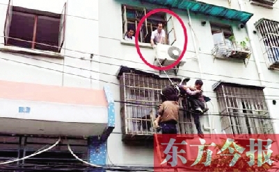 施救現(xiàn)場，劉鵬（圈內(nèi)）先用繩子捆住老太確保安全 勞動(dòng)報(bào)記者 郭娜 供圖