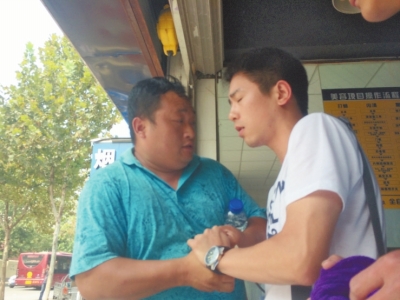 記者正查看照片，突遭藍(lán)衣男強(qiáng)搶手機(jī)。