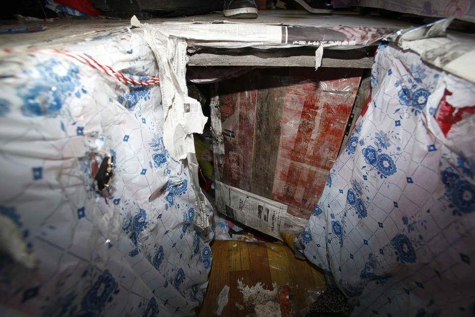 陳小龍在出租屋外，自行又圍起一堵圍墻，安裝了一個門。圍墻上都是豎起的鐵釘，外面堆著土，鄰居猜是從地底挖出來的。洞口就在床邊，0.5米見方，深約1.5米。洞口表面一塊紙板掩蓋，打開紙板跳入洞底，是一扇小木門，木門外有插銷，可以從外面鎖上。