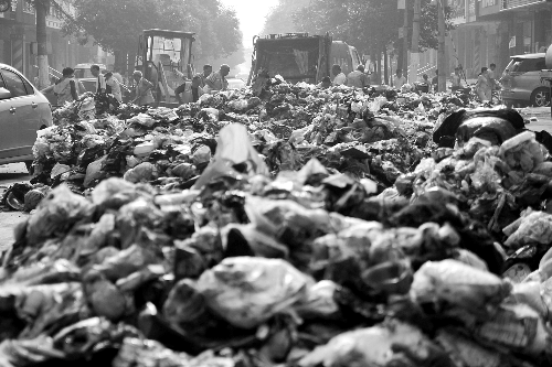 垃圾堆滿整個路口，環(huán)衛(wèi)工人們正在清理