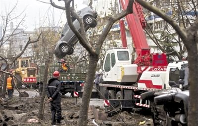 輸油管道爆炸后，搶修人員將被炸毀的車輛運(yùn)出現(xiàn)場(chǎng)。