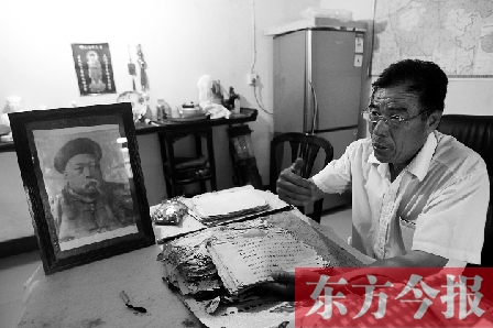 　魏樹紹手拿《物權(quán)法講義》手稿，在講訴先祖書寫“物權(quán)法”的歷史（相框里就是魏聯(lián)奎）