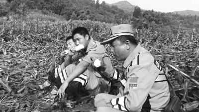 饑餓難忍，中國(guó)緊急救援河南基地的救援隊(duì)員在已毀的玉米地里撿拾生玉米吃。