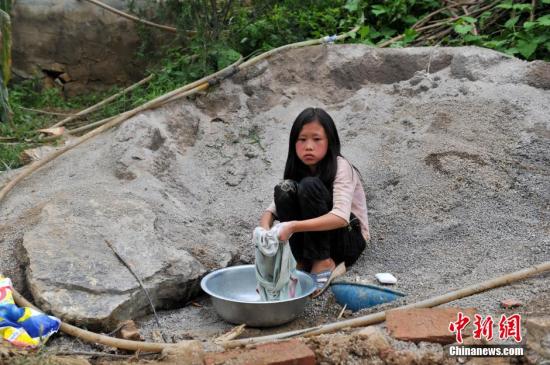 8月9日，云南巧家紅石巖村，10歲的劉鑫蕊在洗自己的衣服
