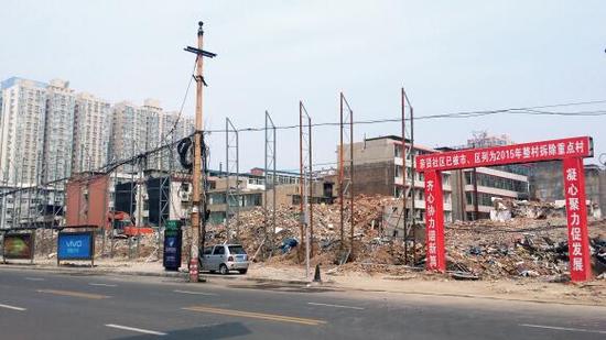 015年5月31日，在社區(qū)干部的帶頭拆遷下，親賢社區(qū)的“城中村改造”拉開帷幕。由于前期“清產(chǎn)核資”及補償標準等因素，拆遷改造工作推進并不順利。圖為位于體育西路東側集體所有的商鋪率先被拆遷完畢，用于遮擋的圍擋正在施工中。（拍攝：2015年9月16日）