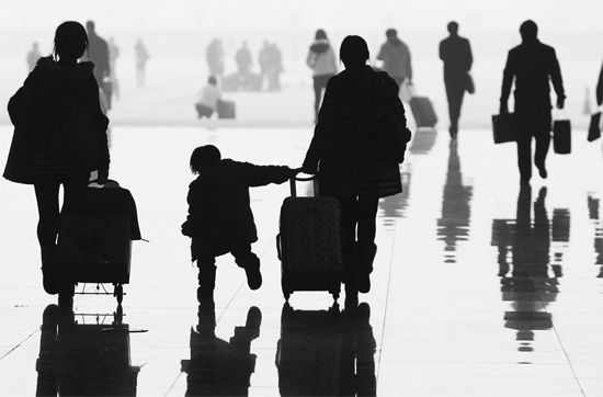 昨日，鄭州東站，一名孩子拉著媽媽和包裹快樂地奔走在春運(yùn)的途中