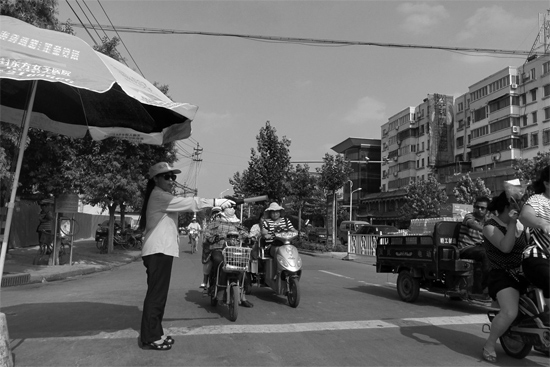 昨日，開封市區(qū)一名協(xié)管員在指揮群眾過(guò)馬路