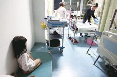 嘟嘟一早就醒了，小小的身體靠在墻邊看著爸爸進行手術(shù)前準備