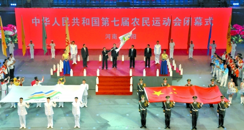 南陽市市長穆為民將農(nóng)運會會旗遞交到下一屆東道主吉林省松原市市長李相國手里。