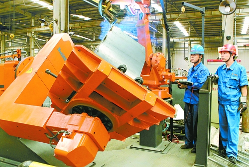 圖為龍工集團(tuán)中原公司的職工正在操作機(jī)器人焊接裝載機(jī)。