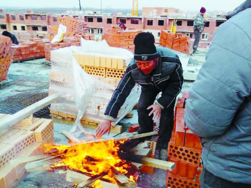 在俄羅斯工地打工時(shí)，因?yàn)樘焯?，工人不得不在工地生火取暖。（圖由方先生提供）