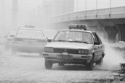 施工的道路上，車輛通過塵土飛揚(yáng)。