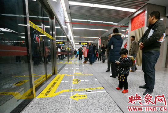 小朋友在等候區(qū)內(nèi)等待地鐵。